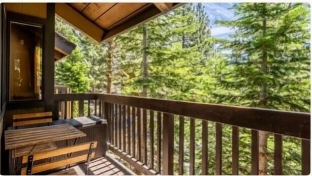 A wooden deck with benches, overlooking a forested area. - NEW & FUN! Hot Tub, EV Outlet in Garage (Mammoth Lakes)