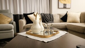 A modern living room with a wooden coffee table, two white vases, and a decorative metal piece on a tray. - Lux Escape w/King Bed/Loft/Skyline Views near BLT (Woodlawn)