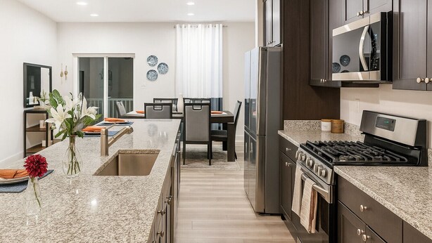 A modern kitchen with granite countertops, stainless steel appliances, and a dining area with a table and chairs. - Lux Escape w/King Bed/Loft/Skyline Views near BLT (Woodlawn)