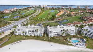 Un resort con varias edificaciones, un amplio espacio de piscina y acceso a la playa.