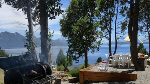 A barbecue grill, outdoor seating, and a view of a lake with mountains in the background. - Upstairs apartment - Seeblick Bariloche (San Carlos de Bariloche)