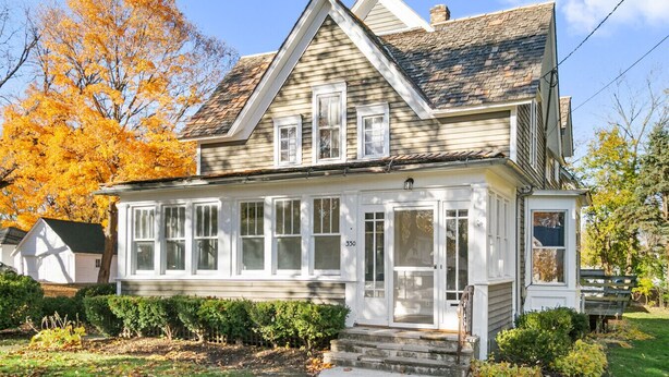 A two-story house with a gabled roof, large windows, and a front porch. - Stylish Retreat in DT Libertyville Near Naval Base (Libertyville)