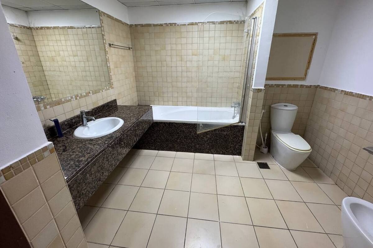 A bathroom with a sink, bathtub, toilet, and a shower area.