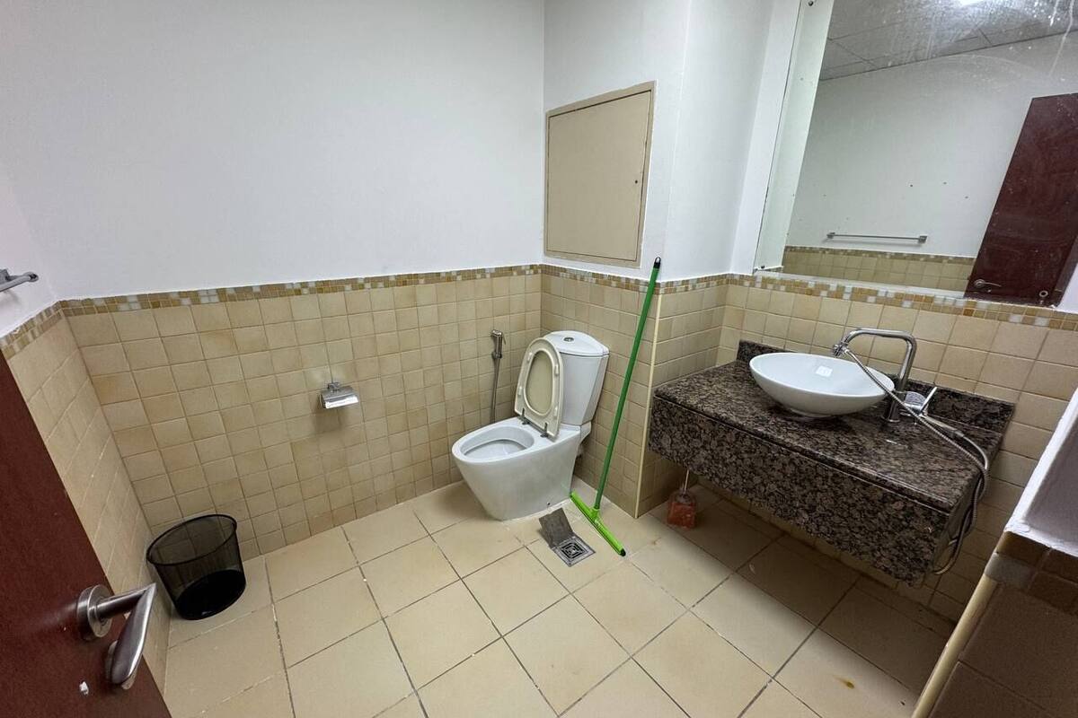 A small bathroom with a toilet, sink, and mirror.