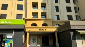 A multi-story building with a green storefront at the ground level. - Casa Nova (Dubai)