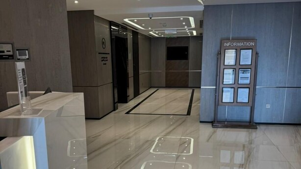 A modern lobby with a marble floor, a reception desk, a digital information board, and a ceiling light fixture. - Casa Nova (Dubai)