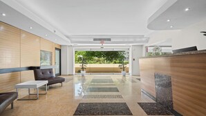 Una hall moderna con reception, area relax e vista sul verde.