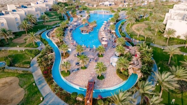 A resort with a central pool, palm trees, and resort buildings. - Sataya Resort Marsa Alam (Qesm Marsa Alam)