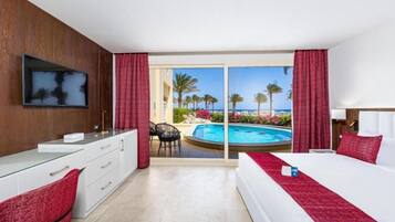 Ein Hotelzimmer mit Bett, Schreibtisch, Fernseher und Blick auf einen Pool und Palmen.