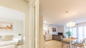 Un appartamento moderno con una camera da letto, zona soggiorno e sala da pranzo.