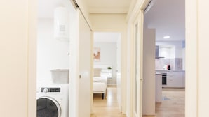 Un appartamento moderno con lavanderia, cucina e zona giorno.