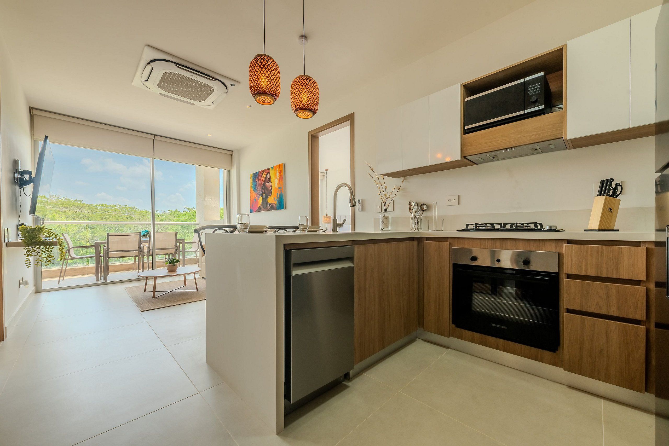 A modern kitchen with a built-in oven, a dishwasher, and a dining area with a table and chairs.