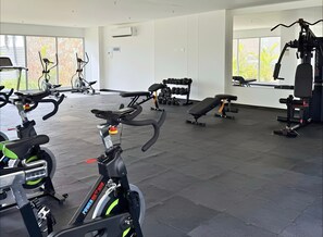 A gym with stationary bikes, dumbbells, benches, and weight machines. - Apartamento premium en Baia Kristal (Cartagena)