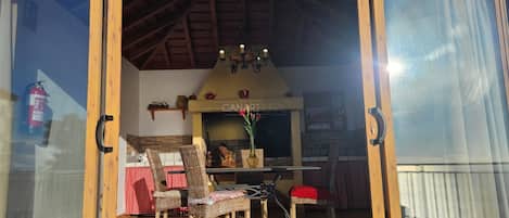 A patio area with a table and chairs, a fireplace, and a fire extinguisher.