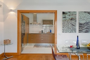 Una cocina moderna con armarios de madera, estufa de acero inoxidable y una mesa de comedor de vidrio.