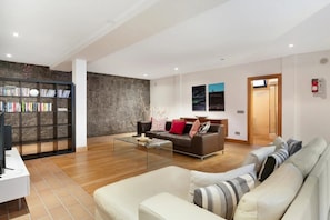 A modern living room with a sofa, coffee table, and a bookshelf.