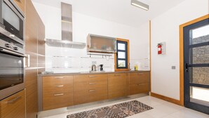 Eine moderne Küche mit Holzausstattung, Edelstahlgeräten und einem gemusterten Teppich.