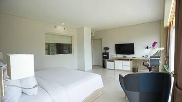 Une chambre d’hôtel moderne avec un grand lit, un bureau équipé d’un ordinateur, une télévision et une chaise.