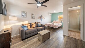 Un salon avec un canapé, une table basse et un ventilateur de plafond.