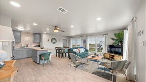 A spacious living area with a kitchen, dining area, and seating space. - Charming Beach House Near Water & Fishing (Surfside)