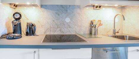 A modern kitchen with a built-in stove, a sink, and a dishwasher.