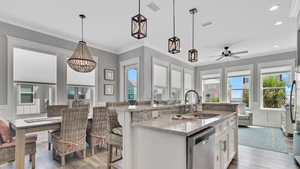 A spacious kitchen with a large island, modern pendant lights, and a view to the outside. - 60 seconds to the Beach Harmony Shores Beach, Pool, Lagoon all just steps away (Gulf Shores)