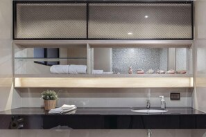A modern bathroom with a large mirror, a sink, a potted plant, and a towel rack. - China Cozy Asoke (Bangkok)