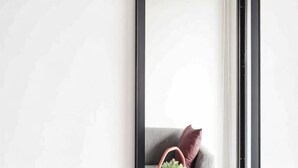 A corner of a room with a gray sofa, a brown cushion, and a small plant. - China Cozy Asoke (Bangkok)