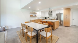 A modern kitchen with a central island, wooden chairs, and built-in cabinets. - Mountain Modern 3-bedroom Lower DV/Old Town Condo (Park City)