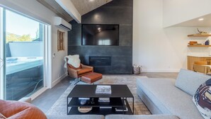 A modern living room with a fireplace, a sofa, a coffee table, and a leather armchair. - Mountain Modern 3-bedroom Lower DV/Old Town Condo (Park City)