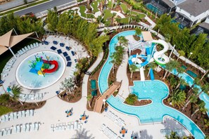Vue aérienne d’un complexe hôtelier doté d’une grande piscine, de toboggans aquatiques et de chaises longues.