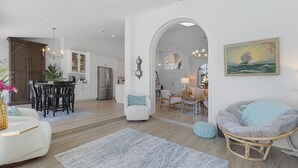 Een ruime woonkamer met een eettafel, een gezellige zithoek, en een keuken op de achtergrond.