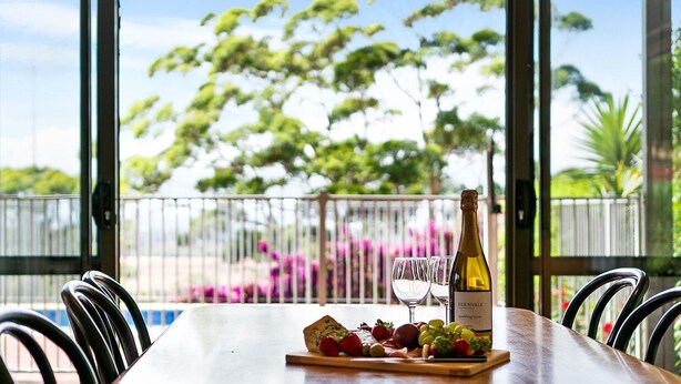 A table with a bottle of Edenvale sparkling wine, glasses, and a fruit platter. - Moondyne Estate Augusta with Pool, Tennis Court and Ocean Views (Deepdene)