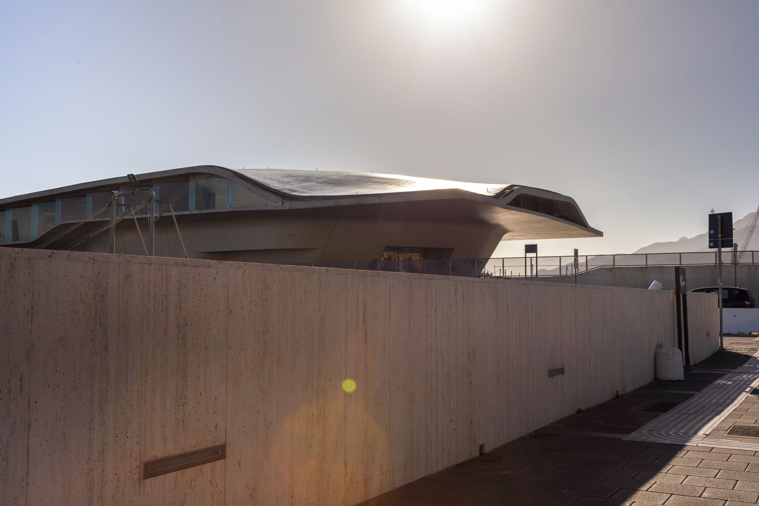 A modern building with a curved roof and a concrete facade.