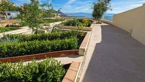 A rooftop garden with various plants and a clear view of the cityscape and ocean. - ViaRomaHome (Salerno)