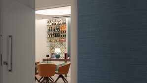 A modern interior with a dining area featuring orange chairs and a marble floor. - ViaRomaHome (Salerno)