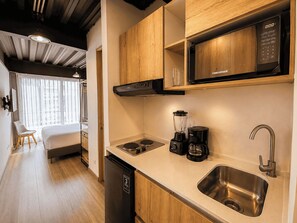 A compact kitchenette with a microwave, a coffee maker, and a sink.