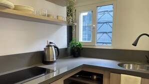 A modern kitchen with a built-in stove, a kettle, and a sink. - Nova Iorque Suites by Avia Suites (Bogotá)