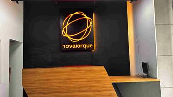 Una recepción con un letrero de neón que dice 'novaiorque' y una barra de madera.