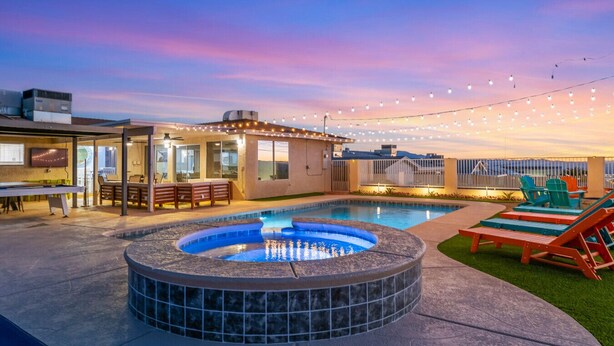 A rooftop pool area with a hot tub, outdoor seating, and string lights. - The Desert Oasis- Pool, Spa, Game Room, Basketball, Pickleball (Lake Havasu City)
