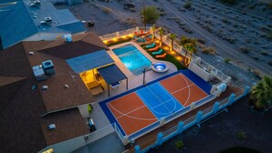 An aerial view of a residential property with a swimming pool, a basketball court, and a covered patio area. - The Desert Oasis- Pool, Spa, Game Room, Basketball, Pickleball (Lake Havasu City)