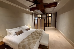 A bedroom with a large bed, a ceiling fan, and a view of a hallway. - Colonial loft in Cartagena old town (Cartagena)