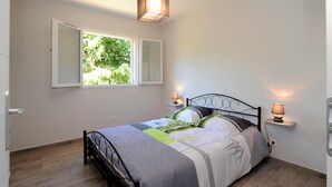 Un dormitorio con cama, ventana y dos lámparas de noche.