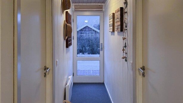 A narrow hallway with a view of a snowy landscape through a door. - 3 bedroom pet friendly home in Hemmet (Hemmet)