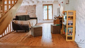 A rustic room with a wooden staircase, a bed, a desk, and a bookshelf. - Le moulin - ST-LAURENT-DE-CERDANS (ST-LAURENT-DE-CERDANS)