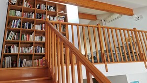 A staircase with wooden railings leading to a room with a bookshelf filled with books.