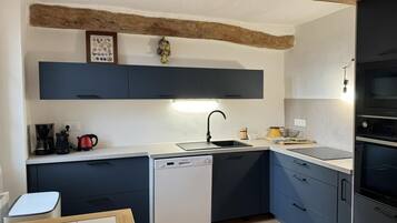 Una cocina moderna con armarios azul oscuro, lavavajillas, un fregadero y horno empotrado.