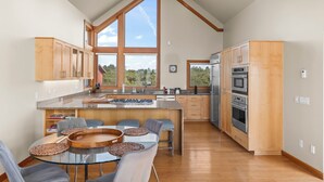 Una cocina moderna con armarios de madera, una isla grande y vistas al exterior.