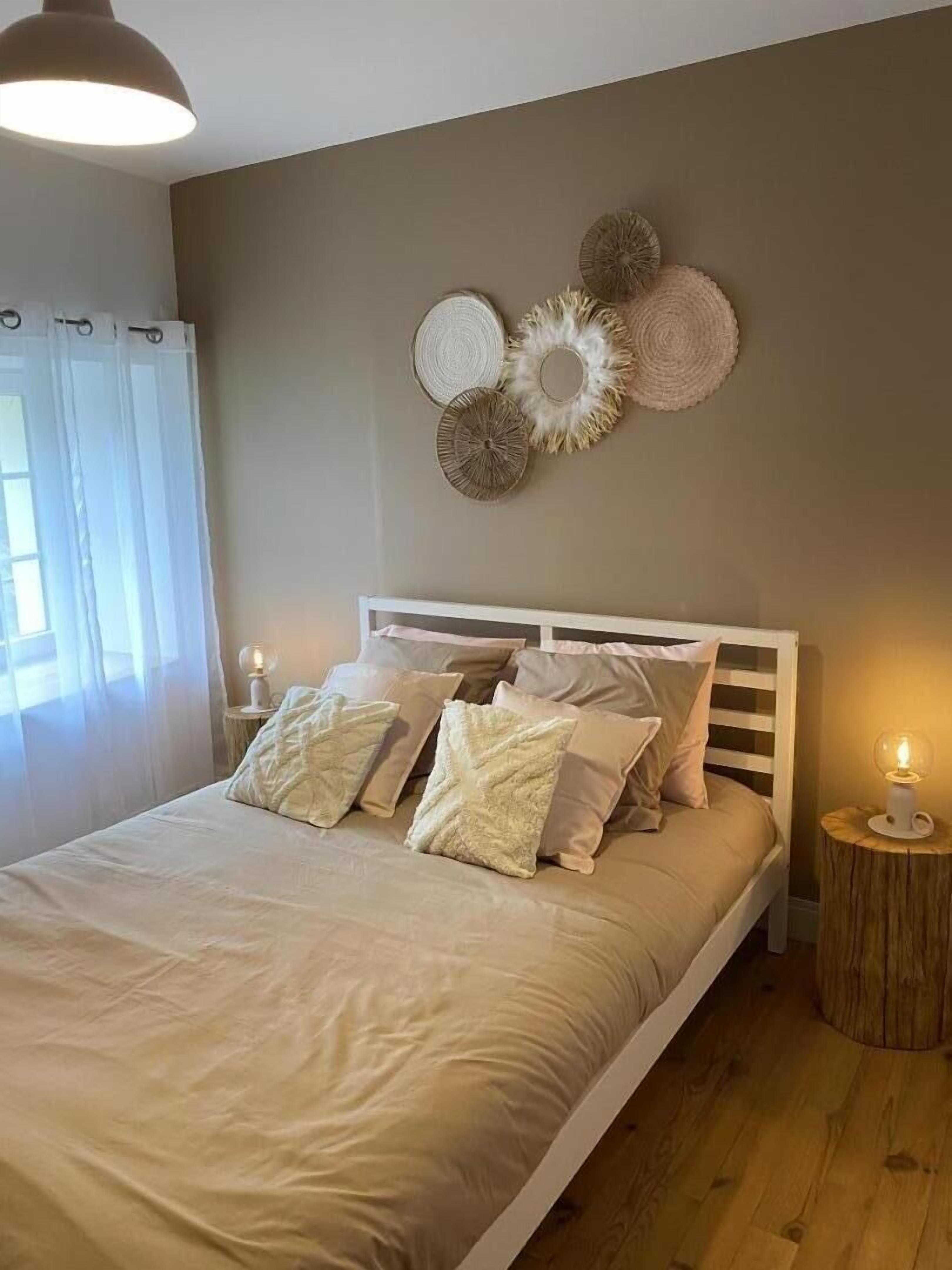 Une chambre à coucher avec un lit, des tables de chevet et des éléments de décoration murale.