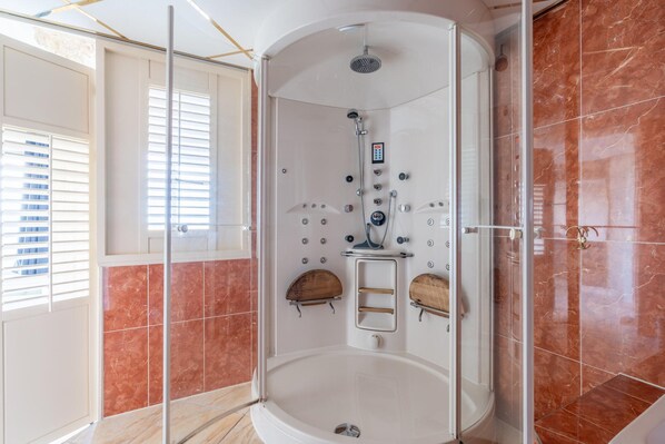 A walk-in shower with a control panel, wooden shelves, and a glass door. - 2 Person sea View Apartment (De Koog)